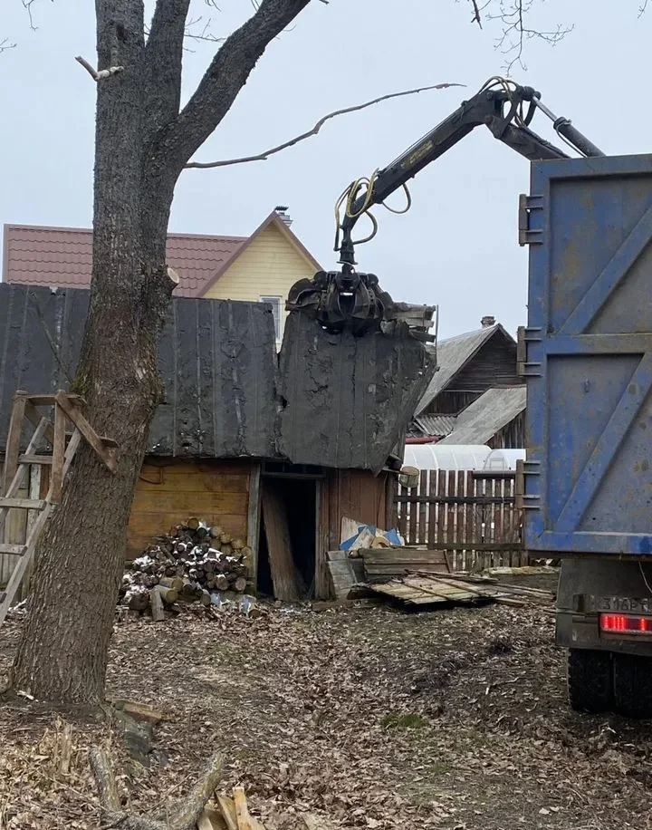 Ломовоз с грейфером разбирает и загружает элементы постройки